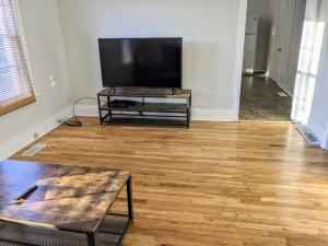 a living room with a flat screen tv and a wooden floor at Moline 1 BR Near TaxSlayer and Downtown in Moline