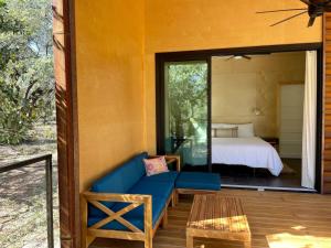 a living room with a blue couch and a bed at Gorgeous Modern Cabin w Heated Pool, Firepit in Dripping Springs +48 photos