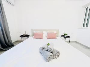 a bedroom with a white bed with towels on it at SUNSHINE SUITS - BRAND NEW APARTMENTS in Msida