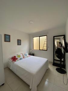 Schlafzimmer mit einem weißen Bett und einem Spiegel in der Unterkunft apto caney 301 in Cali