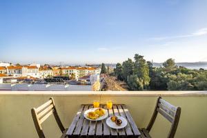 una mesa de madera con platos de comida en el balcón en WHome | 270º Panoramic View Premium Apartment en Lisboa