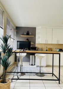 a kitchen with a desk and stools in a room at Live, explore & entertain in the City! in Cape Town