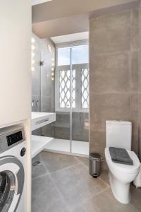 a bathroom with a toilet and a washing machine at WHome | 270º Panoramic View Premium Apartment in Lisbon
