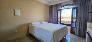 a bedroom with a bed and a large window at CAXU HOSTEL in Cachoeiro de Itapemirim