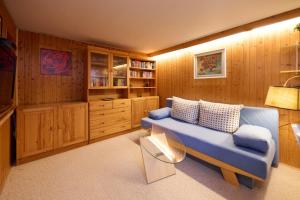 sala de estar con sofá azul y paredes de madera en Wagner´s Residenz, en Heikendorf