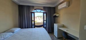 um quarto de hotel com uma cama e uma janela em CAXU HOSTEL em Cachoeiro de Itapemirim