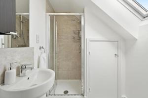 a white bathroom with a sink and a shower at Modern 4 Bedroom House with Parking Basildon in Laindon