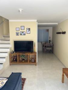 Charmoso Village Praiano في لورو دي فريتاس: غرفة معيشة مع تلفزيون بشاشة مسطحة وطاولة
