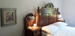 a bedroom with a bed with a wooden head board at Antica Dimora Russit in Mediis