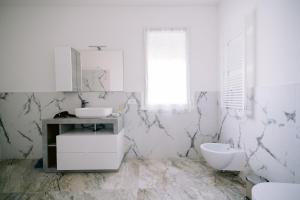 biała łazienka z umywalką i toaletą w obiekcie Residenza La Boheme w Weronie