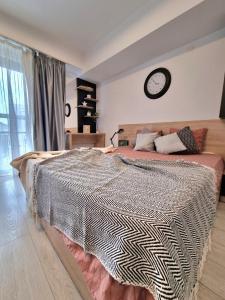 a bedroom with a large bed with a clock on the wall at Studio Central Exer I in Bucharest