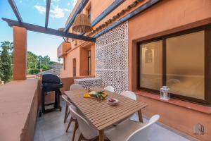 d'une table et de chaises en bois sur un balcon avec barbecue. dans l'établissement Beachside Newly Renovated Apartments - Globales, à Estepona