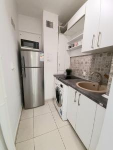 a small kitchen with a sink and a refrigerator at Studio Central Exer I in Bucharest