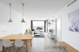 - un salon blanc avec une table et des chaises en bois dans l'établissement Santa Romana Apartments & Suites, à Caldes d'Estrac