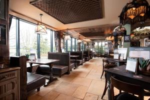 a restaurant with tables and chairs and windows at The Stables - The Inn Collection Group in Whitby