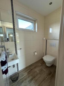 a bathroom with a toilet and a sink and a window at Ferienhaus Eschauel in Nideggen