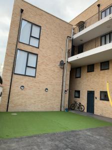 an apartment building with a green lawn in front of it at Icare Lodge Ltd,Safwaan House. in Barking