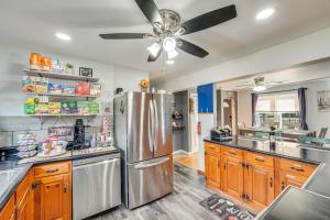 a kitchen with a stainless steel refrigerator and wooden cabinets at Waterfront Wallkill Duplex Home with Fire Pits! in Wallkill