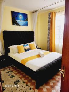 una camera da letto con un letto grande con cuscini gialli di Cosy 1 Bedroom TRM,Thika Rd a Nairobi
