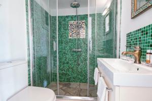 錫米的住宿－Emporio A Captivating 6-Bed Villa in Nimborio，绿色瓷砖浴室设有淋浴和水槽