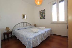 a bedroom with a bed with two towels on it at Alfa Apartmerts in Lido di Pomposa
