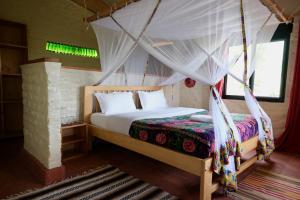 a bedroom with a bed with a mosquito net at Hyena Hill Lodge in Sanga