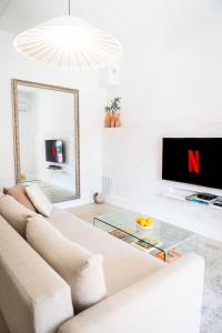 a living room with a couch and a glass table at Spacieux T2 au coeur de la Camargue - 10mn Plage in Salin-de-Giraud