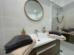 a bathroom with a sink and a mirror at APPART'ICI 3 - Spacieux appartement F3 in Lunel-Viel +21 photos