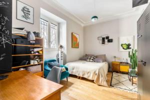 Schlafzimmer mit einem Bett und einem Schreibtisch in der Unterkunft A spacious and very charming nest near Montmartre in Paris