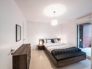 um quarto com uma cama e uma mesa de madeira em Le clos des chênes - terrasse et parking em Castelnau-le-Lez