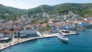 una barca è ormeggiata in un molo in acqua di Hotel San Giorgio a Vis