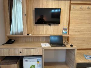 a desk with a laptop and a television on a wall at Beyond OTEL in Antalya