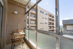 Apartamento con balcón con mesa y ventana grande. en Alvares Araújo - Apartamento Familiar perto da Estação de Comboios en Braga