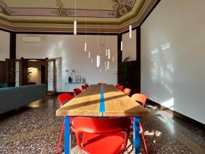 a conference room with a wooden table and red chairs at Frame Bologna in Bologna