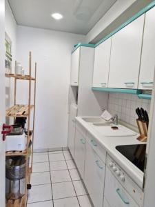 a kitchen with white cabinets and a sink at Apartment mit Balkon, Küche & Waschmaschine an der WHU in Vallendar