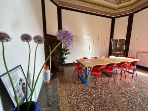 una sala de conferencias con mesa y sillas rojas en Frame Bologna en Bolonia