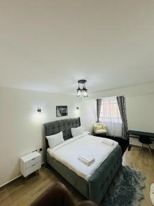Un dormitorio con una gran cama blanca y una ventana en Azania Homes 2bedrooms Apartments Westlands, en Nairobi