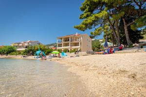 a group of people on a beach near the water at Apartments Villa Alba in Banjol