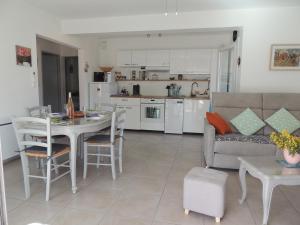 Una cocina y una sala de estar con un sofá y una mesa. en Petit Paradis a Saint Mandrier 1 chambre plage à 4 mn CLIM Parking Wifi, en Saint-Mandrier-sur-Mer
