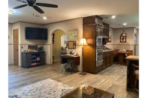 uma sala de estar com uma ventoinha de tecto e uma secretária em StockYards! Walk 3 Blocks-Ranch House sleeps 8 em Fort Worth