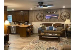 a living room with a couch and a kitchen at StockYards! Walk 3 Blocks-Ranch House sleeps 8 in Fort Worth