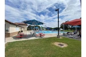 patio ze stołami i parasolami oraz basenem w obiekcie StockYards! Walk 3 Blocks-Ranch House sleeps 8 w mieście Fort Worth