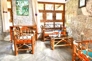 um grupo de cadeiras e uma mesa num quarto em Cabañas Tosepan Kali em Cuetzalan
