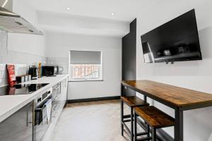 a kitchen with a counter and a wooden table at Wiverton Apt #5 - Central Location - Free Parking, Fast WiFi and Smart TV by Yoko Property in Nottingham