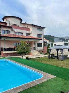 a swimming pool in front of a house at Вила Фреди in Varna City