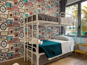 a bedroom with a bunk bed and a wall of pictures at Ostello Bello Milano Duomo in Milan