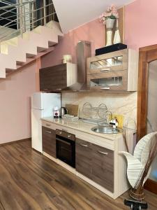 a kitchen with a sink and a staircase at Вила Фреди in Varna City