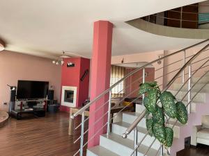 a living room with a staircase with a green dragon sculpture at Вила Фреди in Varna City