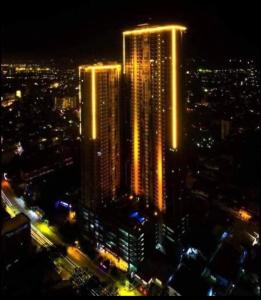 Horizon 101 Shean Cityscape Studio Type Condo في مدينة سيبو: مدينة مضاءة ليلا مع مباني طويلة