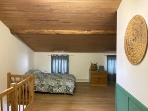 um quarto com uma cama e um tecto de madeira em La maisonnée Auvergnate em Auzelles